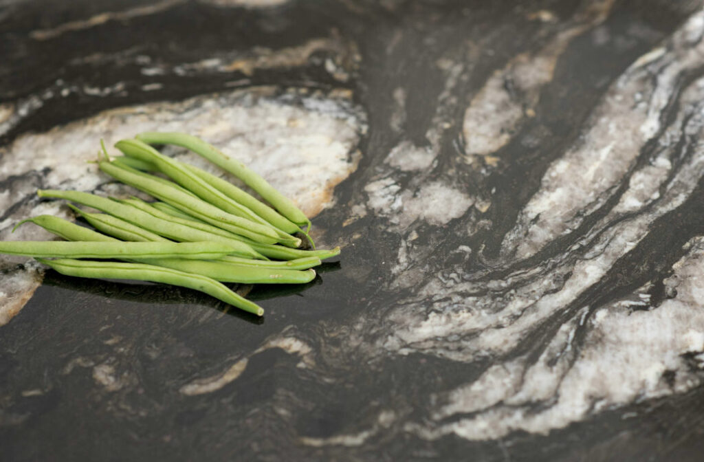 Black Marble Slab Countertop With Green Beans In Kitchen