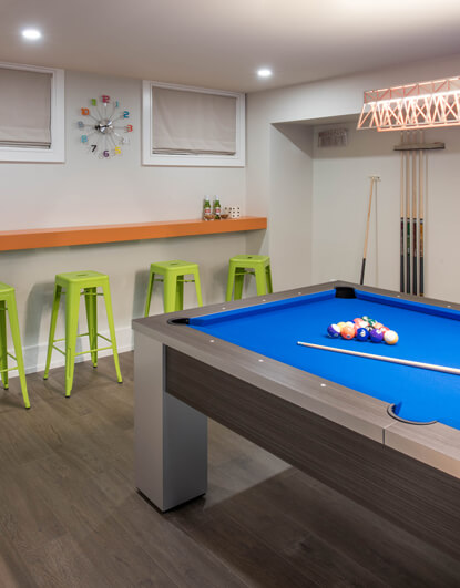 Basement Pool Table With Green And Orange Bar Seating