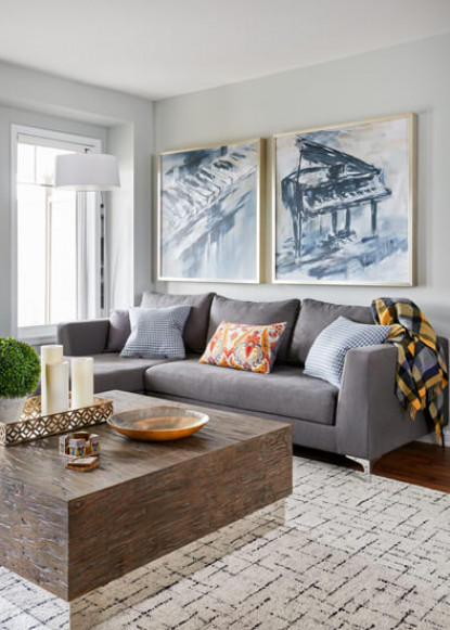 living-room-with-gray-sofa-and-accent-pillows-and-modern-coffee-table-and-art-wall-with-blue-abstract-painting-and-geometric-rug