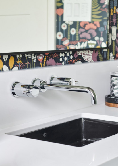 renovated-bathroom-with-white-countertop_undermount-black-sink-wall-mounted-taps-and-faucet