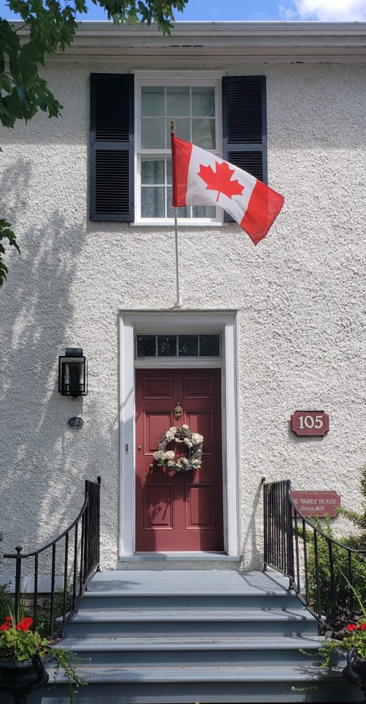 White Stucco House Burgundy Front Door Canada Flag