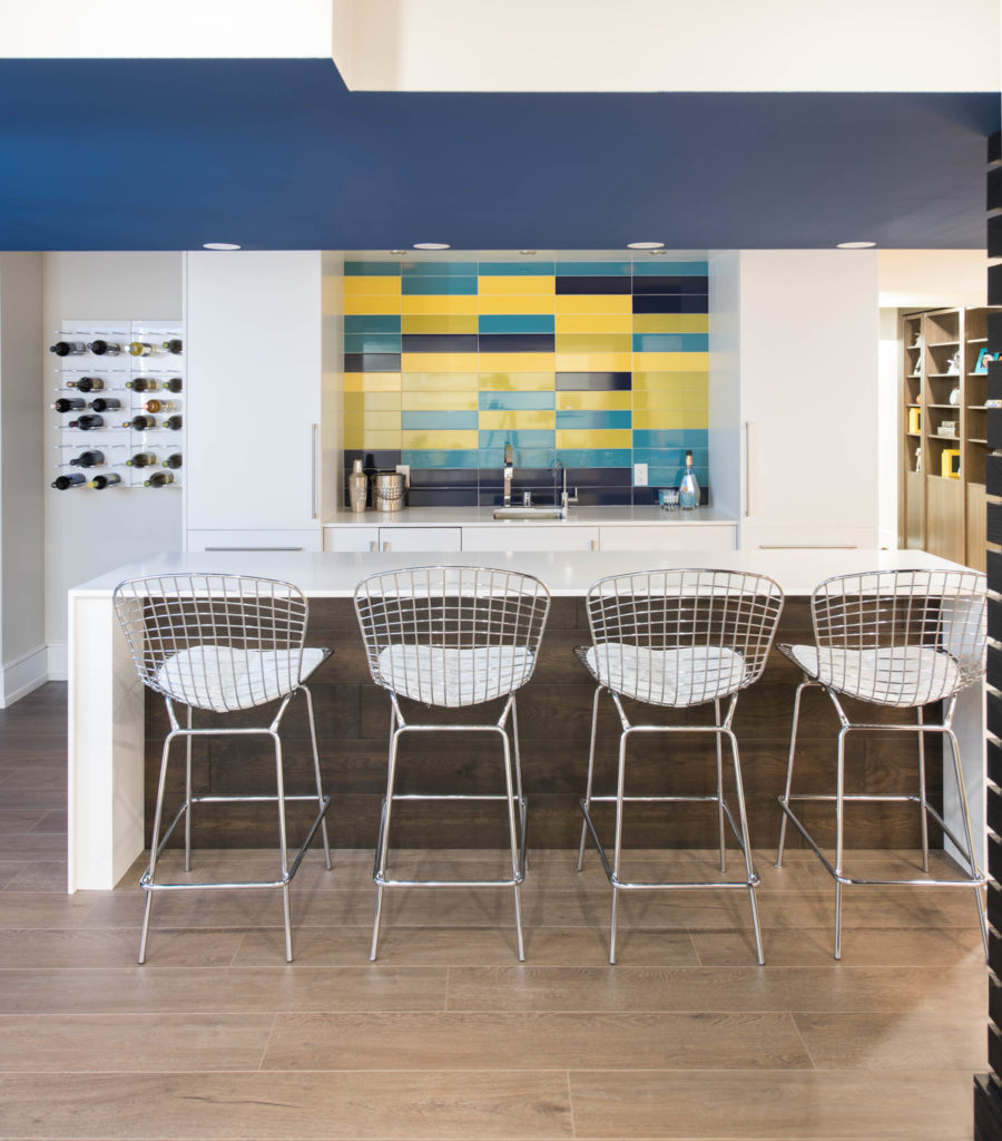 Basement Kitchen With Fun Blue And Yellow Backsplash And Wine Rack