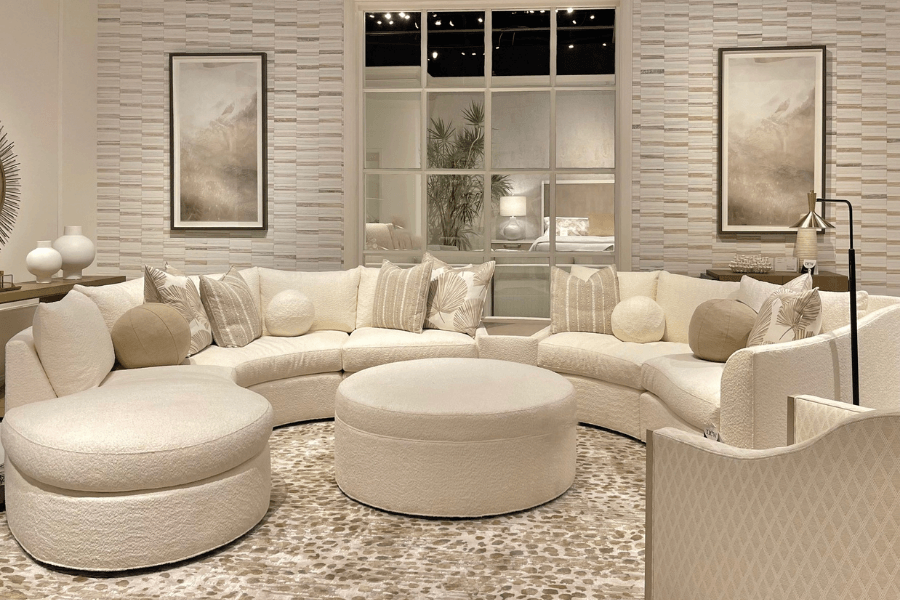 neutral living room, graphic wall paper, cream sectional, round coffee table, neutral area rug, round pillows, sphere pillows, cream vase, 