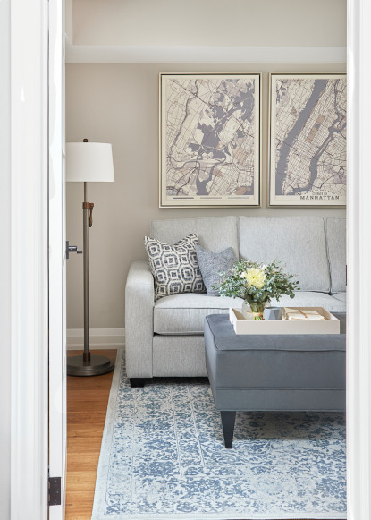 gray-living-room-with-gray-sofa-ottoman-and-blue-accessories-benjamin-moore-collingwood