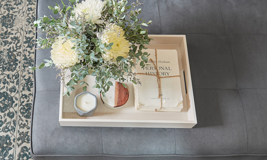 gray-upholstered-ottoman-white-tray-florals