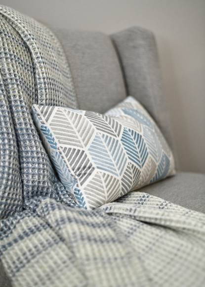 gray-accent-chair-with-kidney-pillow-blue-and-white-throw-blanket