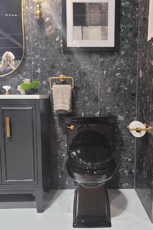 black toilet, dark gray cabinetry, black tile, gray tile