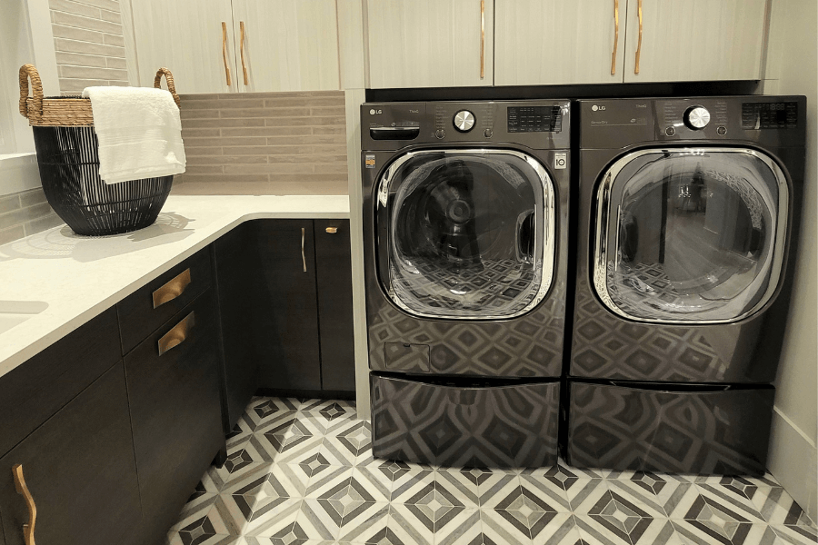 black and cream laundry room, black washing machine, black diamond tile, black tile, black cabinetry