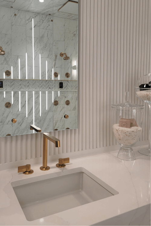 Fluting millwork, white vanity, gold faucet, brass taps, New American Home bathroom