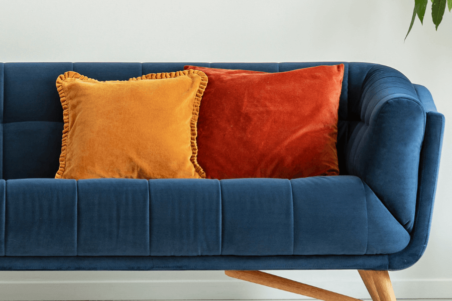 Yellow And Burnt Orange Velvet Cushions On Blue Velvet Sofa