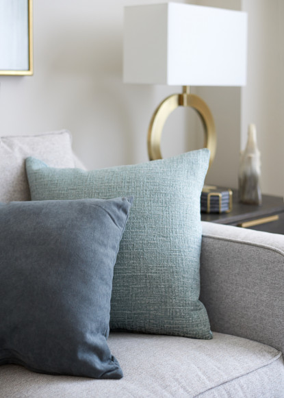 blue-and-teal-accent-pillows-on-gray-sofa