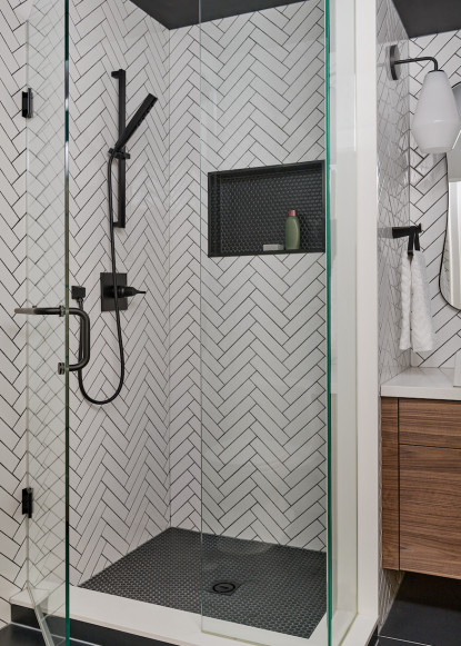 black-and-white-bathroom-black-plumbing-fixtures-herringbone-subway-tile-black-penny-round-niche