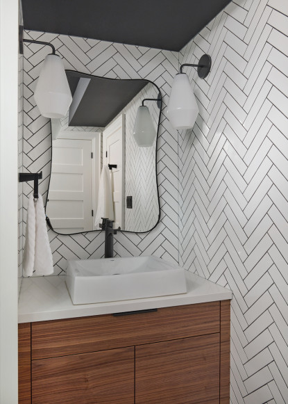 black-and-white-bathroom-contrasting-herringbone-subway-tile-on-walls-floating-vanity